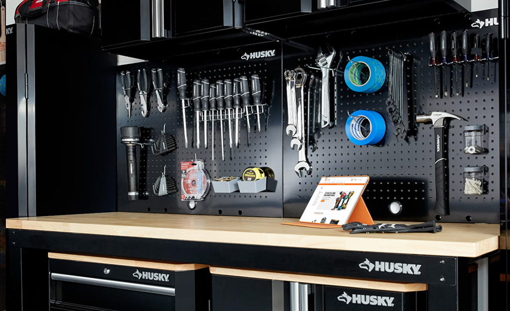 Tools stored vertically on a pegboard in a garage.