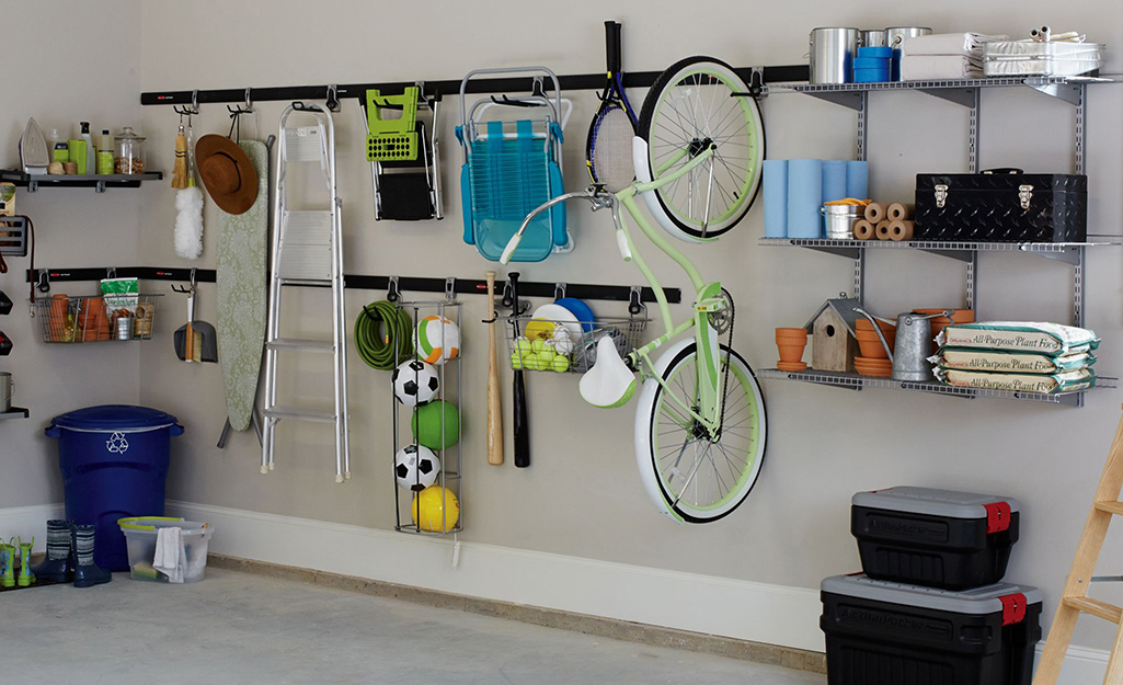 Track systems on a garage wall provides vertical storage for a bicycle, step ladder, sports equipment and more.