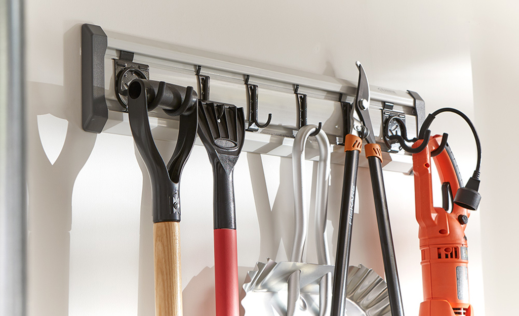 Wall hooks support large tools for yard work.