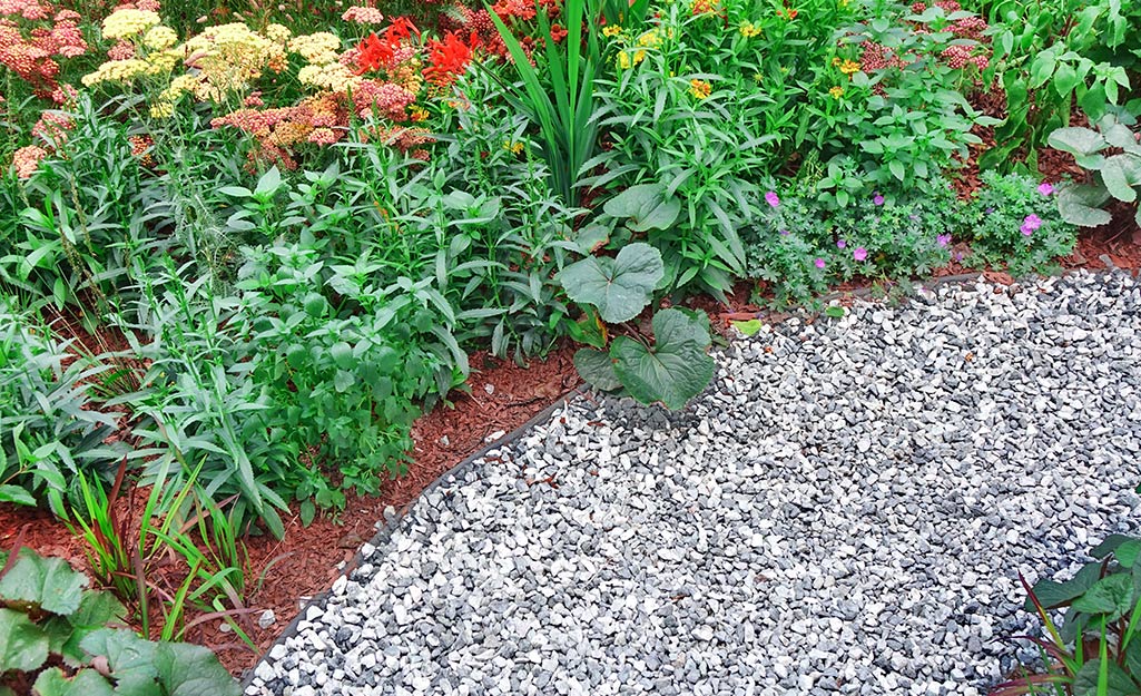 Landscaping rocks as a pathway near a garden.