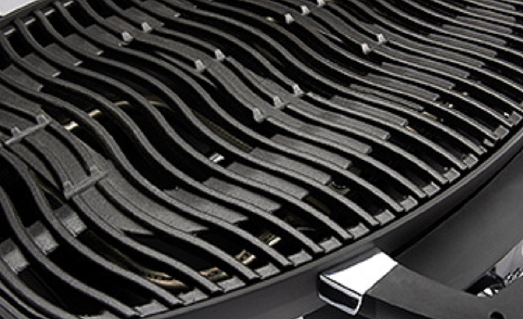 A gas grill has a grate made of porcelainized cast iron.