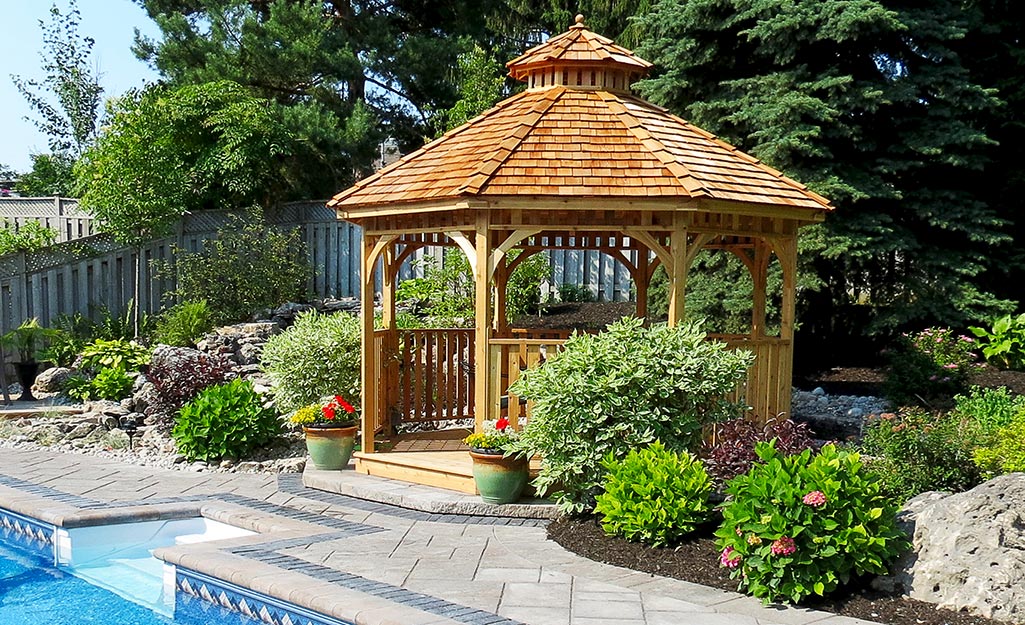 A gazebo with a cupola beside a pool.