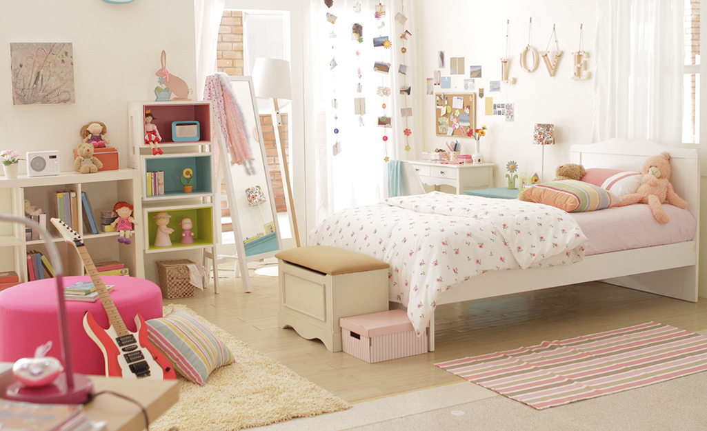 Girl's bedroom with craft space, pink ottoman and guitar.