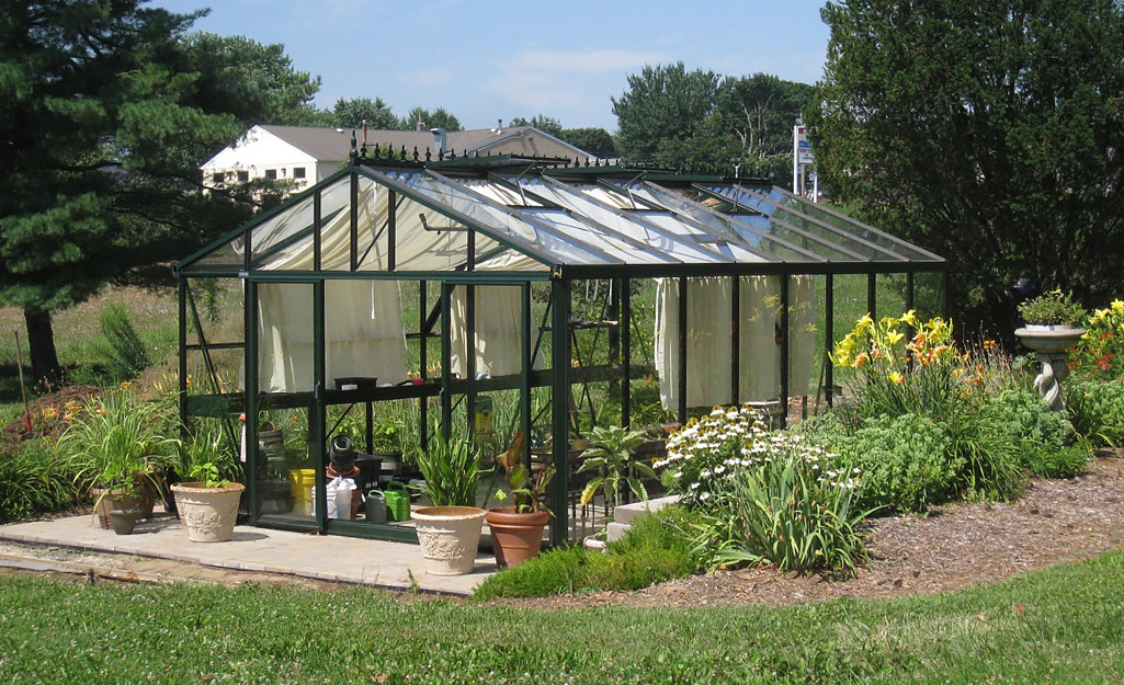 A greenhouse with glass panels and canvas sheets. 