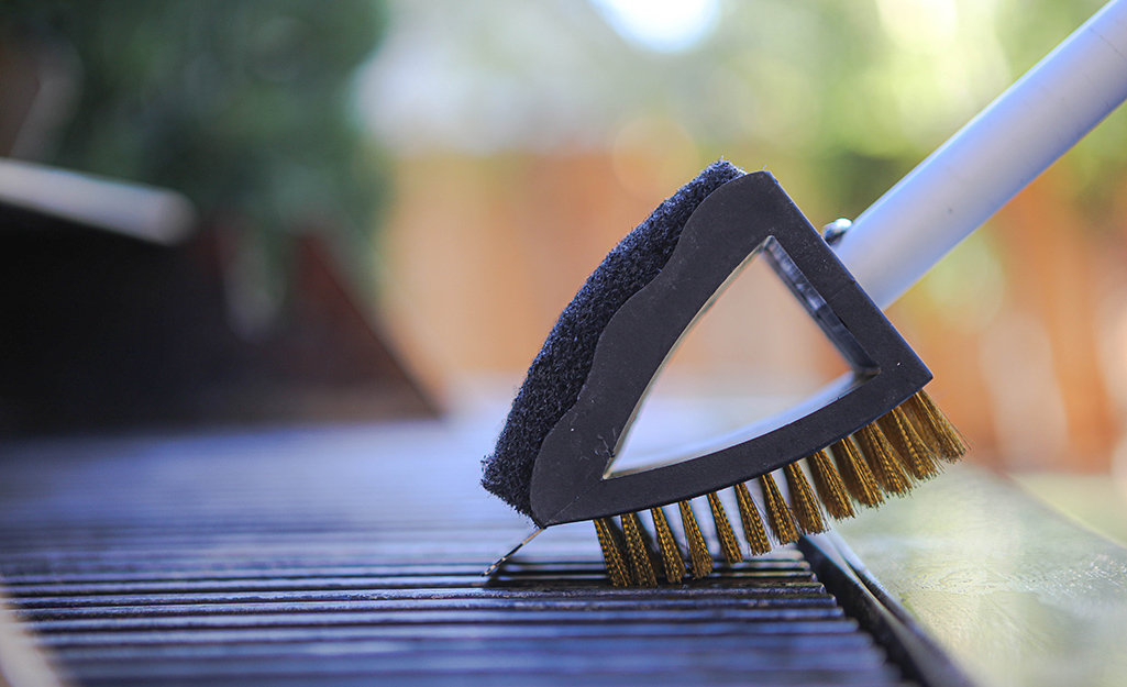 A grill brush is used to clean a grill grate.