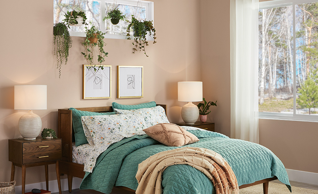 Guest bedroom with wall art, decor, plants and curtains