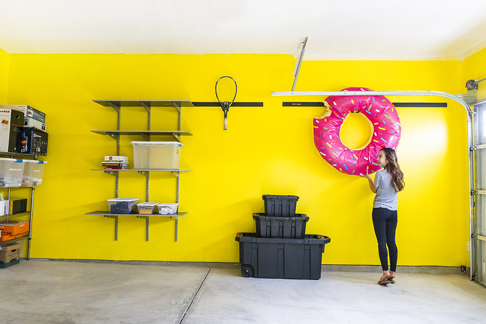 A person storing an inflatable donut in garage