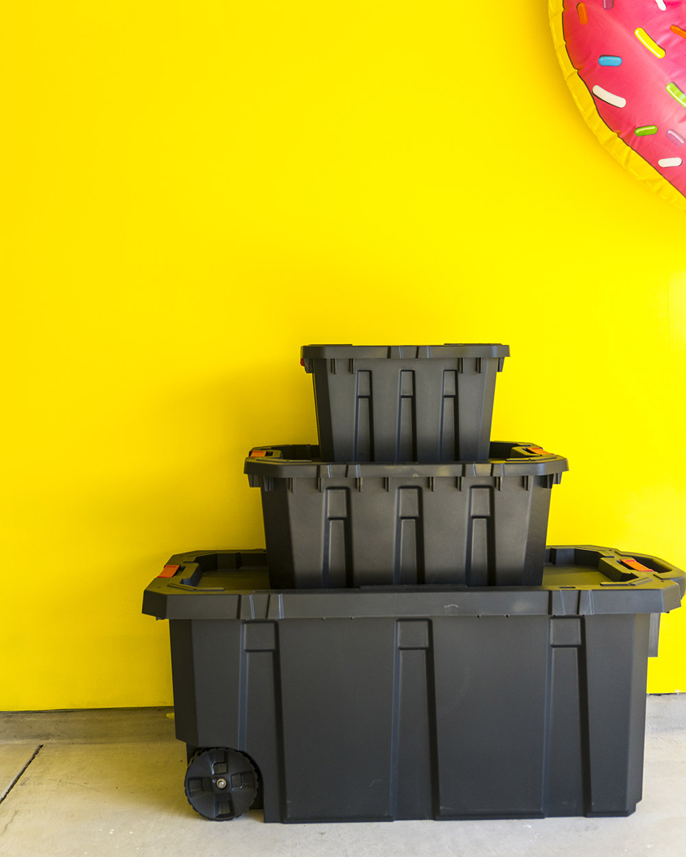 Black storage bin stacked against wall