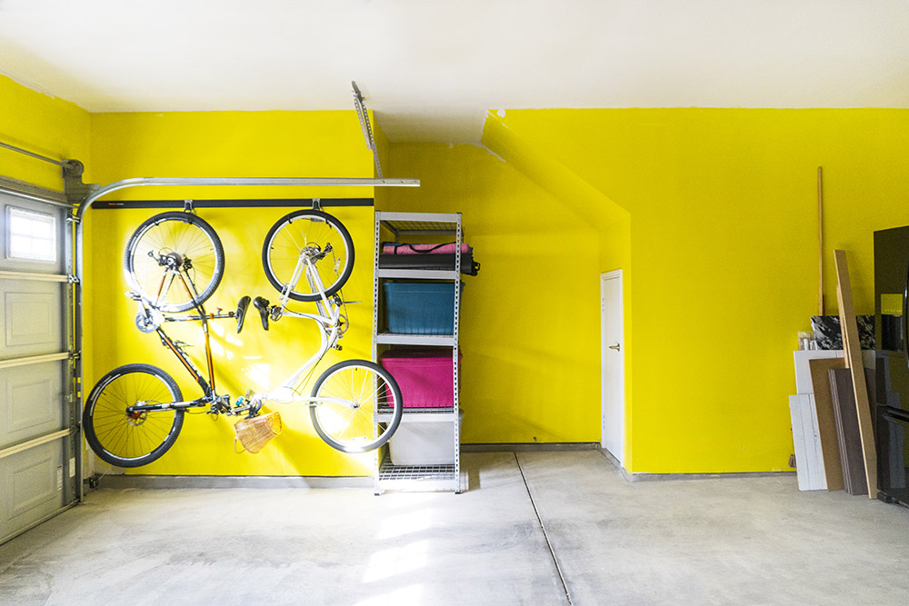 Garage wall painted yellow and bicycles hanging 