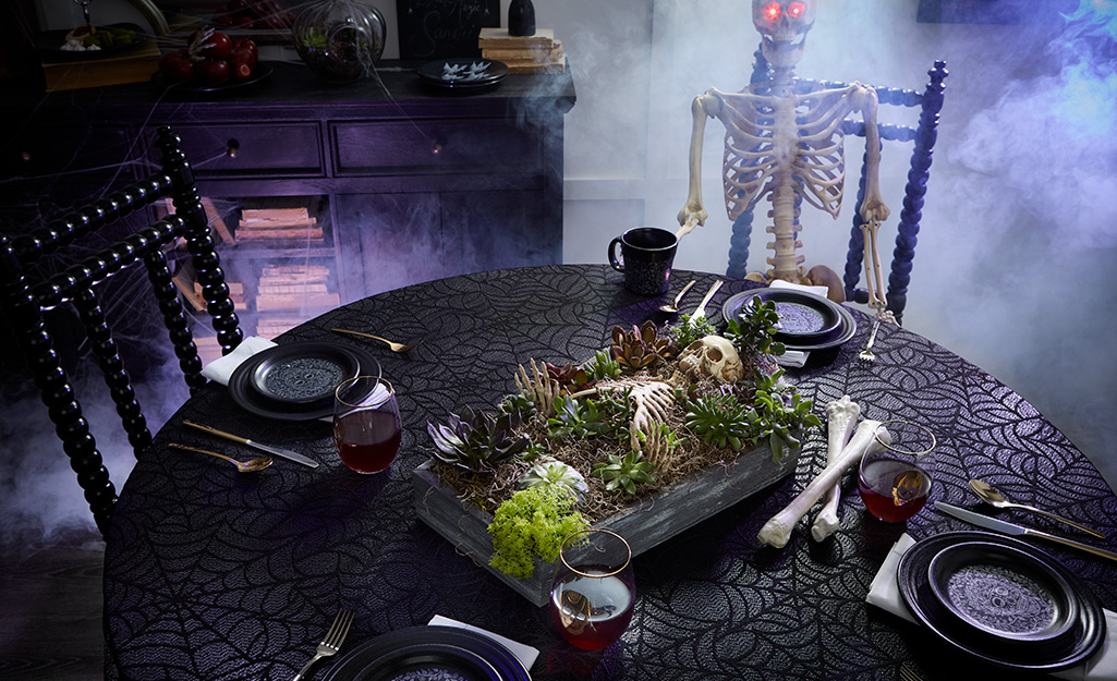 A table with a halloween coffin centerpiece.