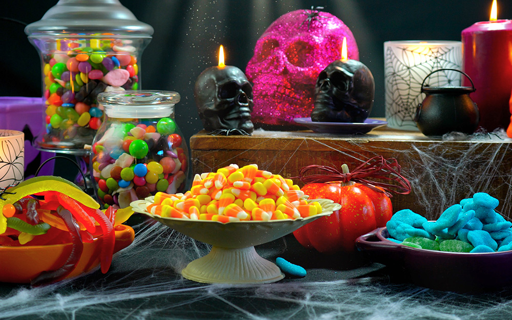 A table decorated for halloween with a candy centerpiece.