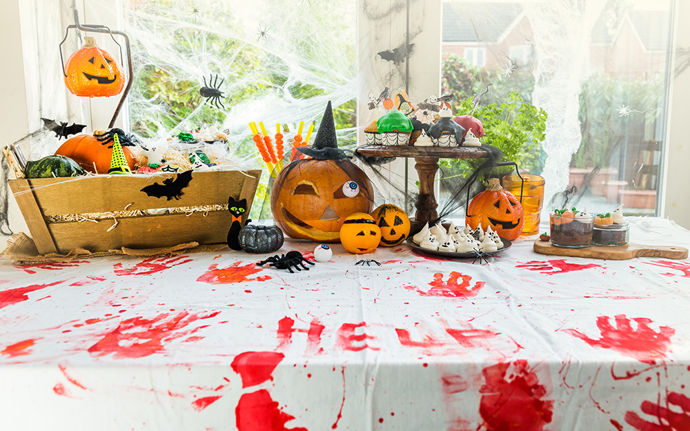 A table decorated for halloween with bloody hand prints.