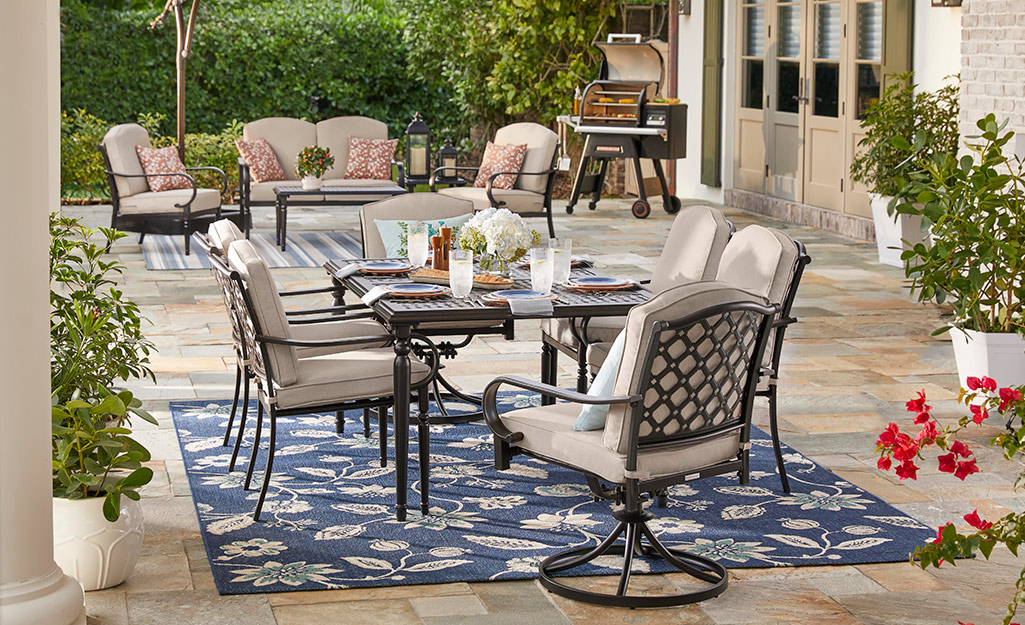 A Hampton Bay patio set with a table and six chairs with red cushions.