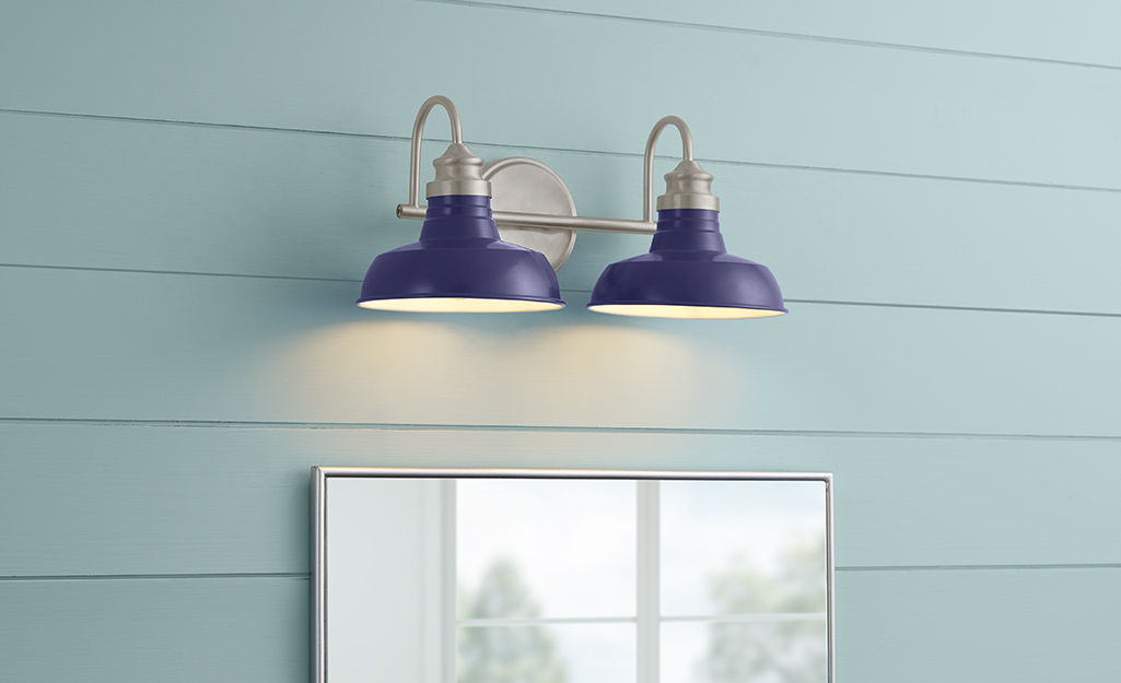 A Hampton Bay wall sconce with three down lights with frosted shades.