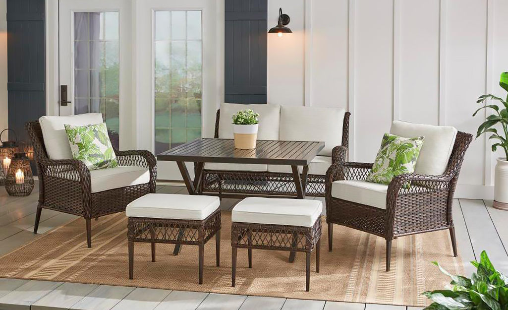 A Hampton Bay patio set in brown wicker with white cushions.
