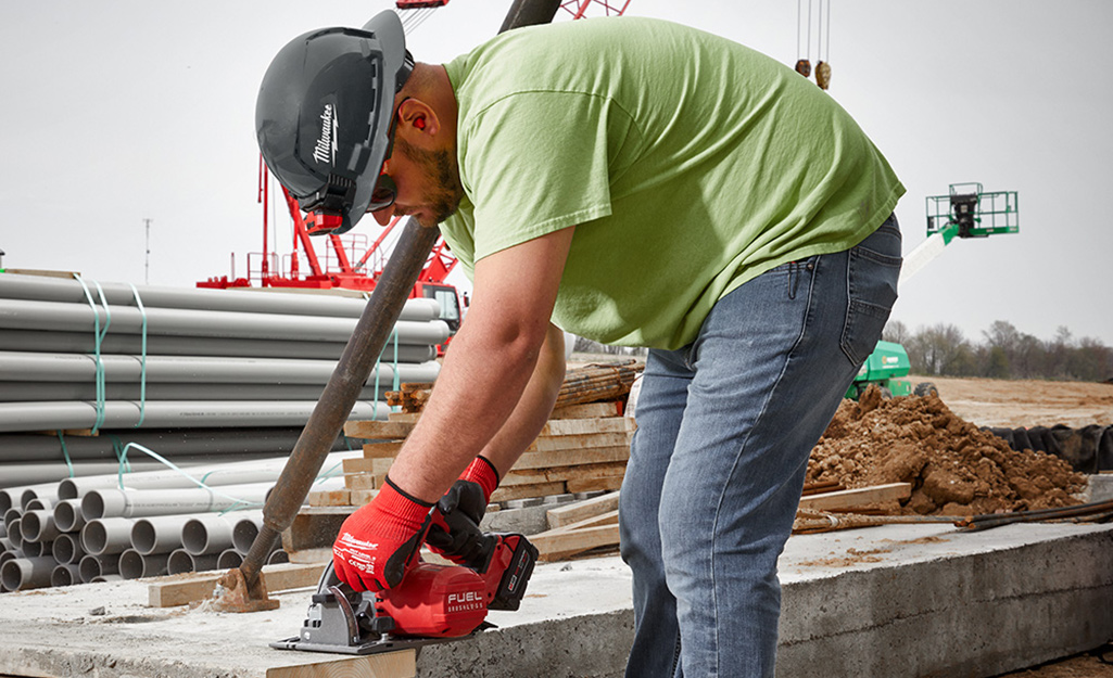 A man working on top of a building wearing a hard hat