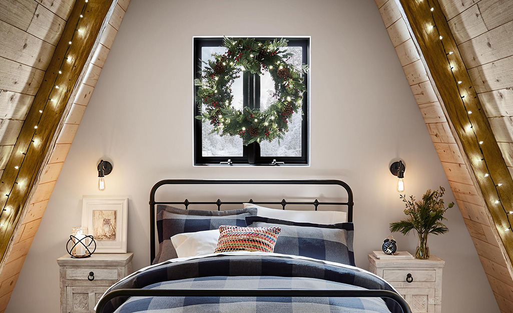 A bedroom with a wreath on the window.
