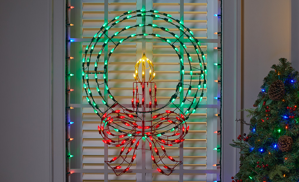 A wire wreath with lights on a door.