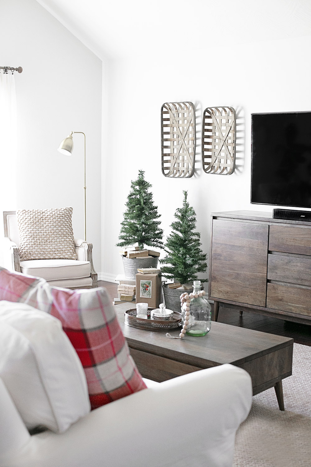 A living room with two small Christmas trees