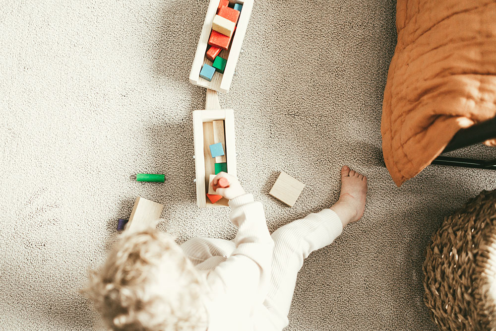 a person playing toys on carpet 