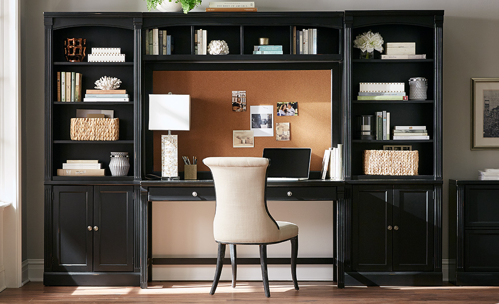 A home organization cabinet features shelves connected to a desk in a home office.