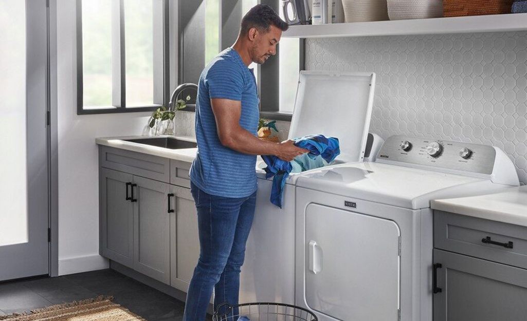 A man using a washing machine.