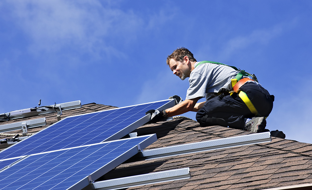 A person installing solar panels on a roof.