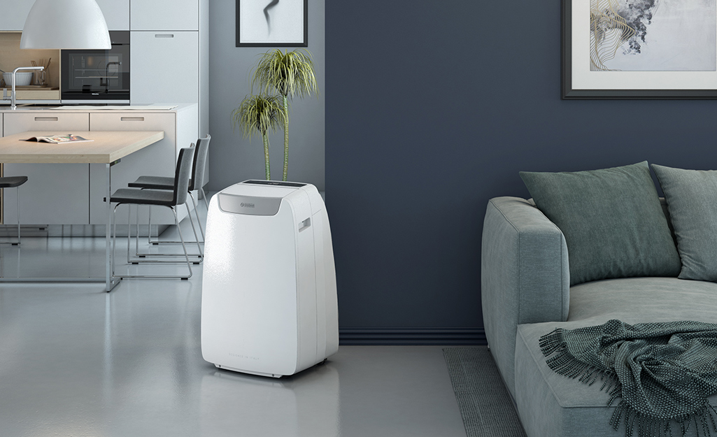 A freestanding portable air conditioner in a living room.