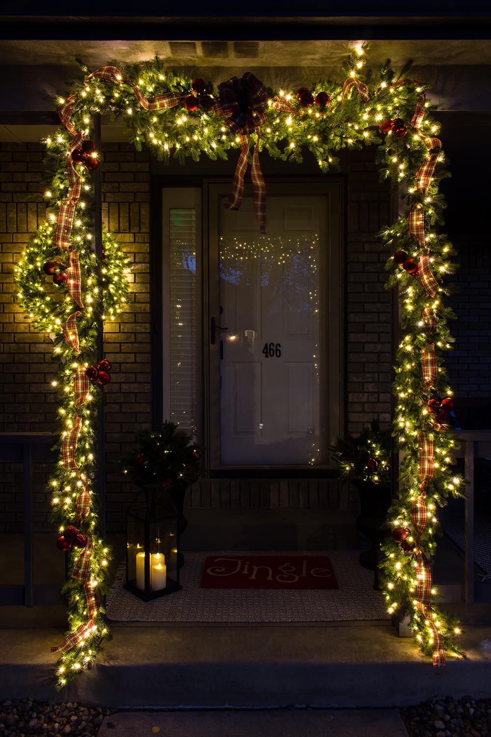 Front porch with Christmas decor with lights on at night