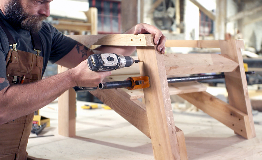 A person attaching the back support for an Adirondack chair.