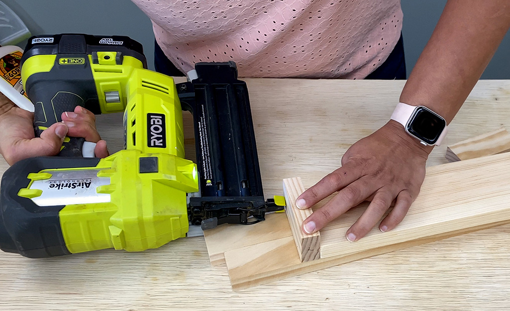 A person attaching piece of wood.