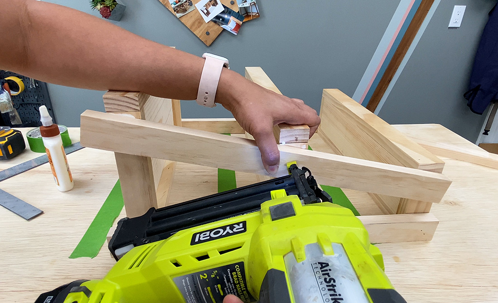 A person assembling pieces of wood with a drill.