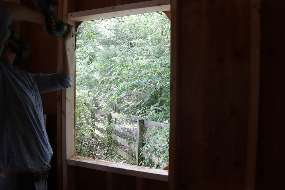 A person cutting out a window frame