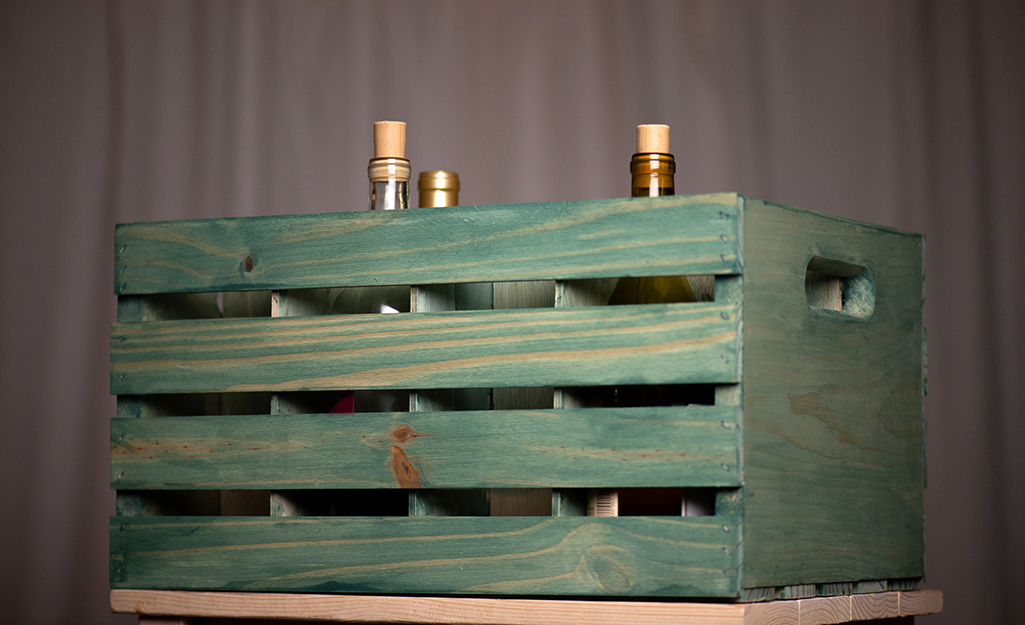 A wooden beverage that has been stained green to illustrate the step Finishing Touches - Build a Beverage Crate