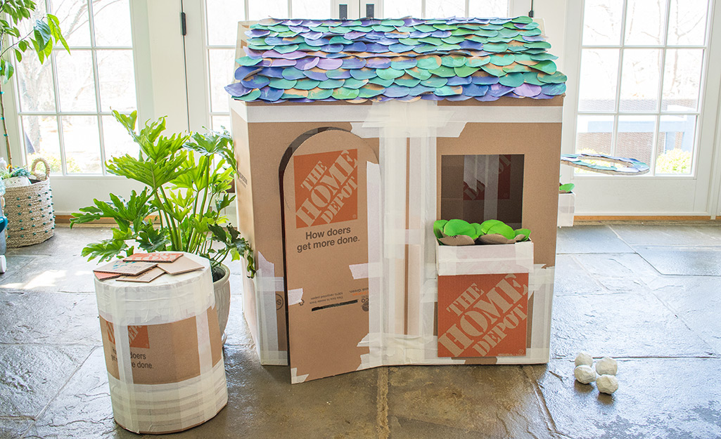 A deluxe cardboard playhouse with colorful paper shingles.