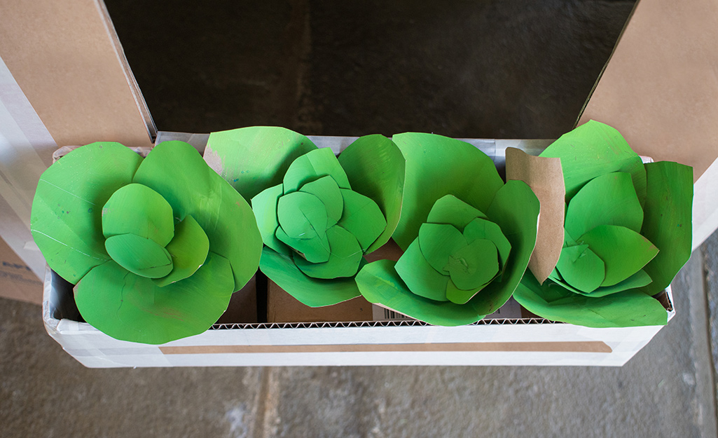 A box of paper flowers with green petals.
