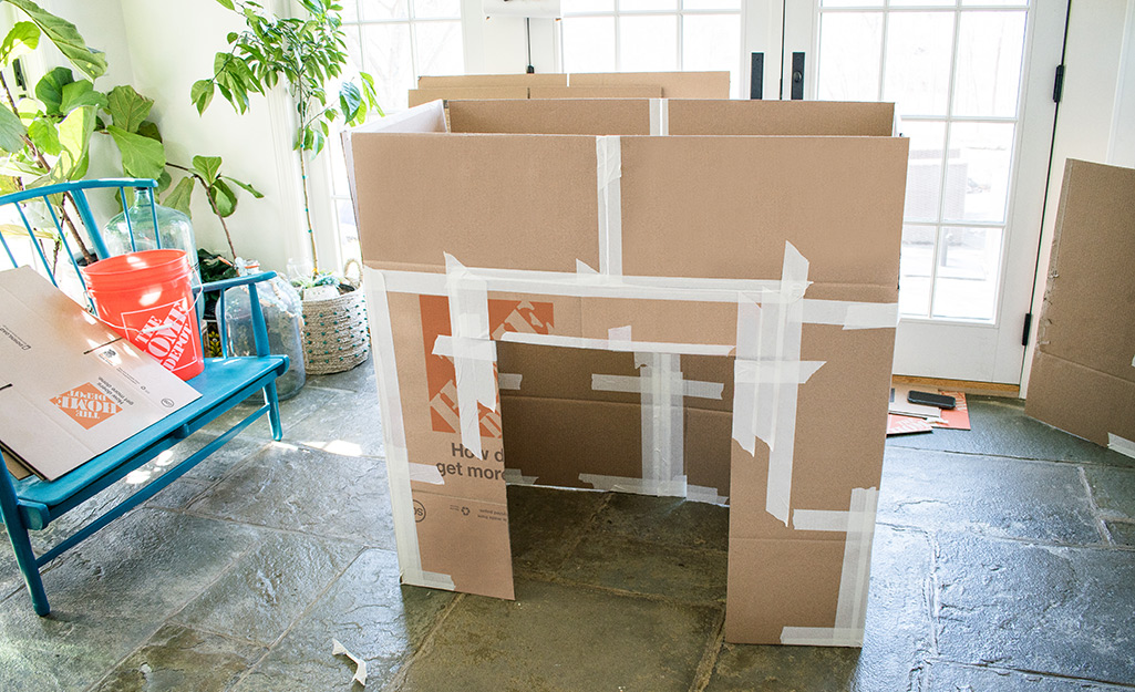 A partially assembled deluxe cardboard playhouse.