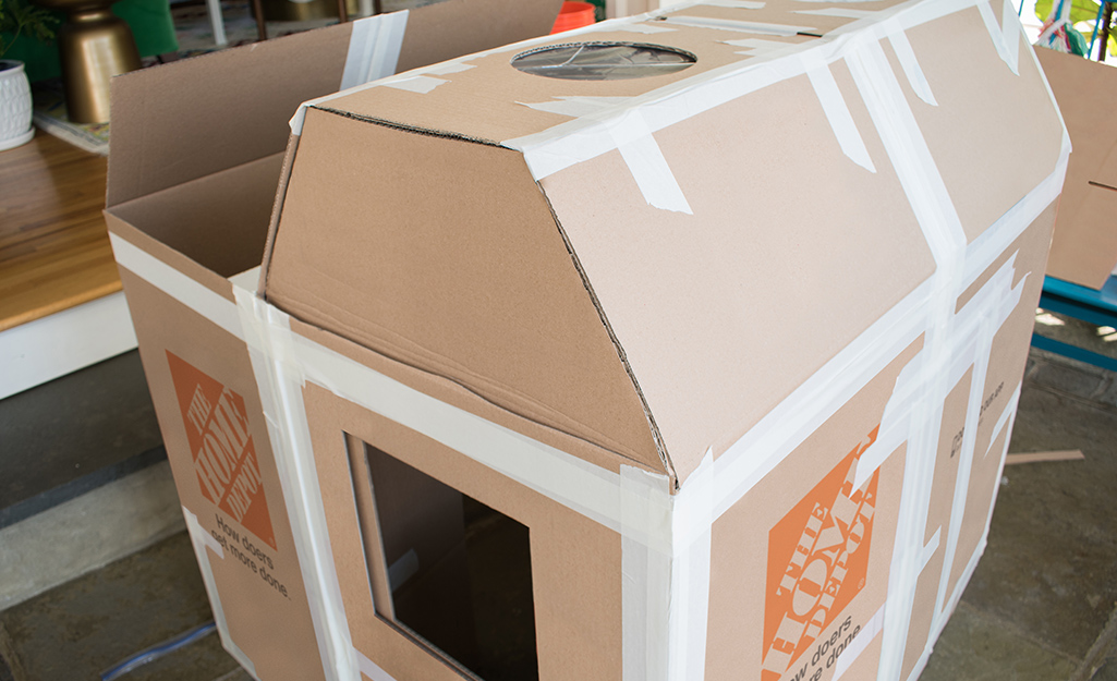 Skylights attached to the roof of a deluxe cardboard playhouse.