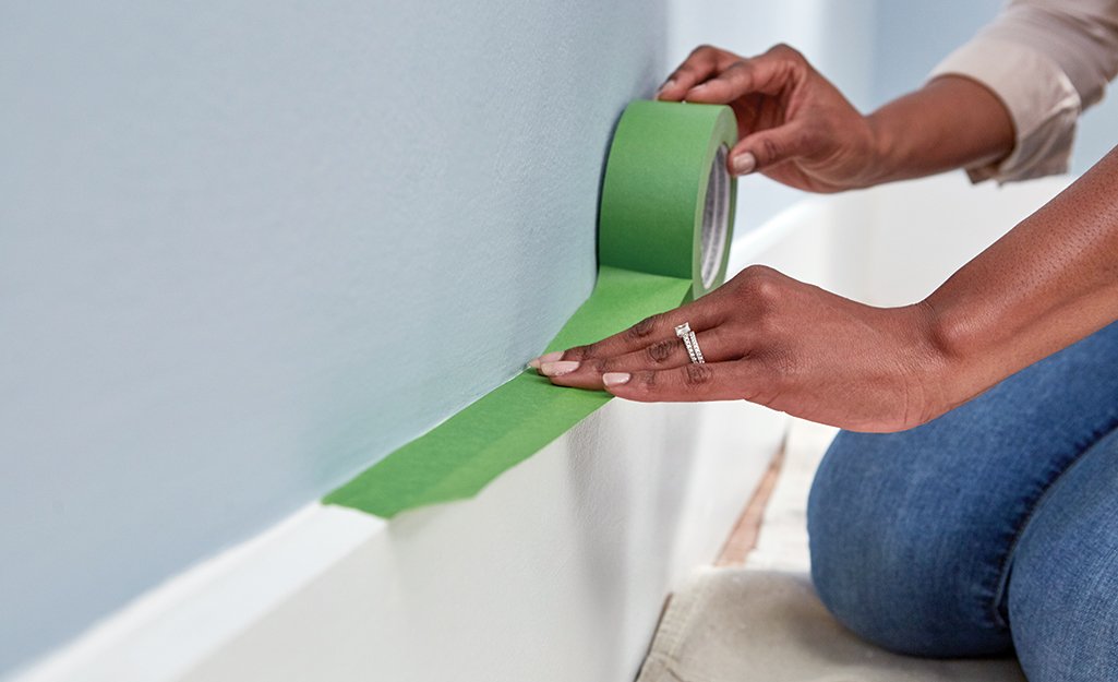 Painter's tape is used to protect baseboards.