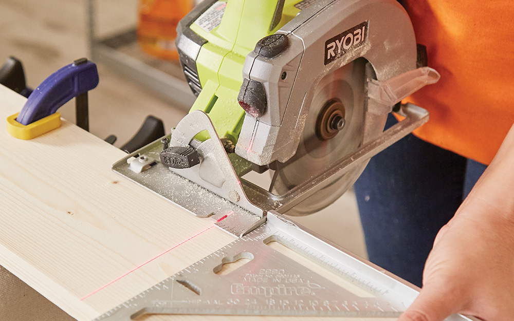 A person cutting wood with a circular saw. A person cutting wood with a circular saw.