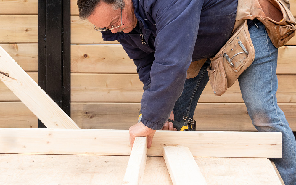 Someone drilling a wood screw into a board. Someone drilling a wood screw into a board.