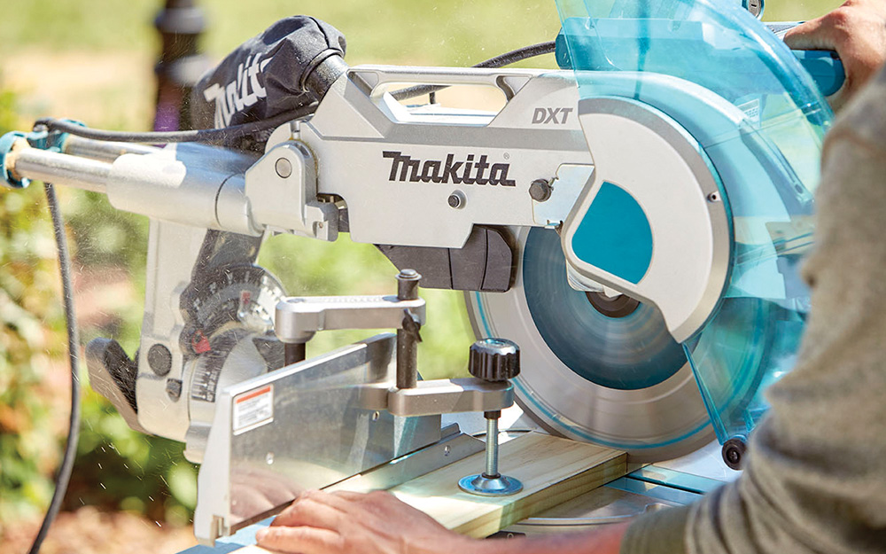 A person using a miter saw to cut wood A person using a miter saw to cut wood