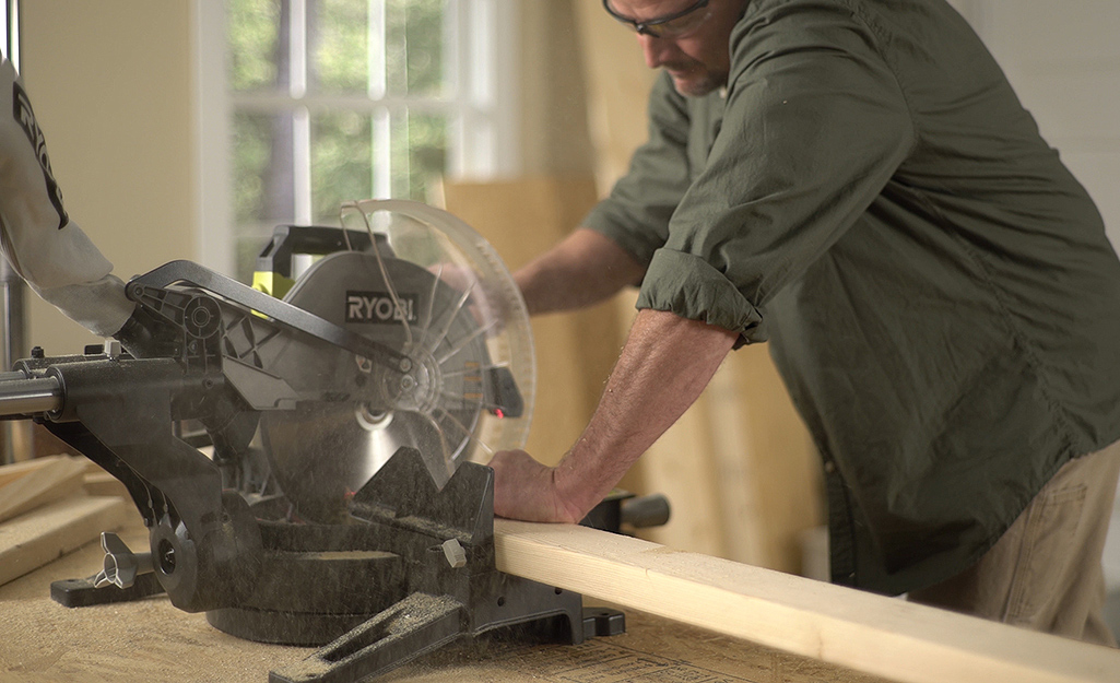 A man using a circular saw to cut a piece of lumber. A man using a circular saw to cut a piece of lumber.
