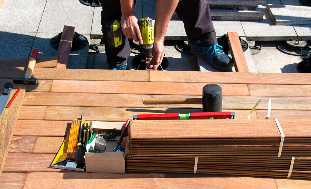 Deck boards, tools and other materials gathered on a deck.