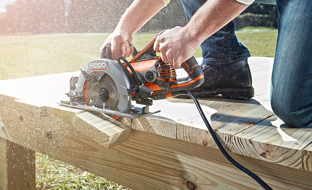 Decking boards are trimmed using a saw. Decking boards are trimmed using a saw.