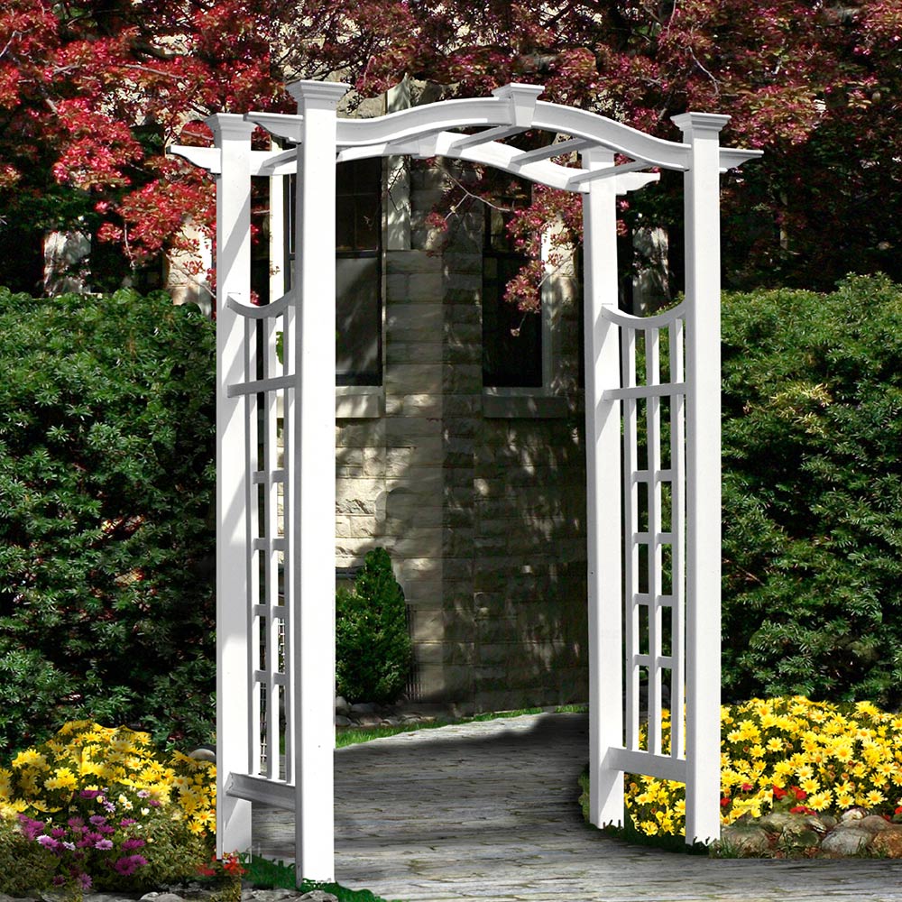A white garden arbor with a trellis on its sides spans a walkway.