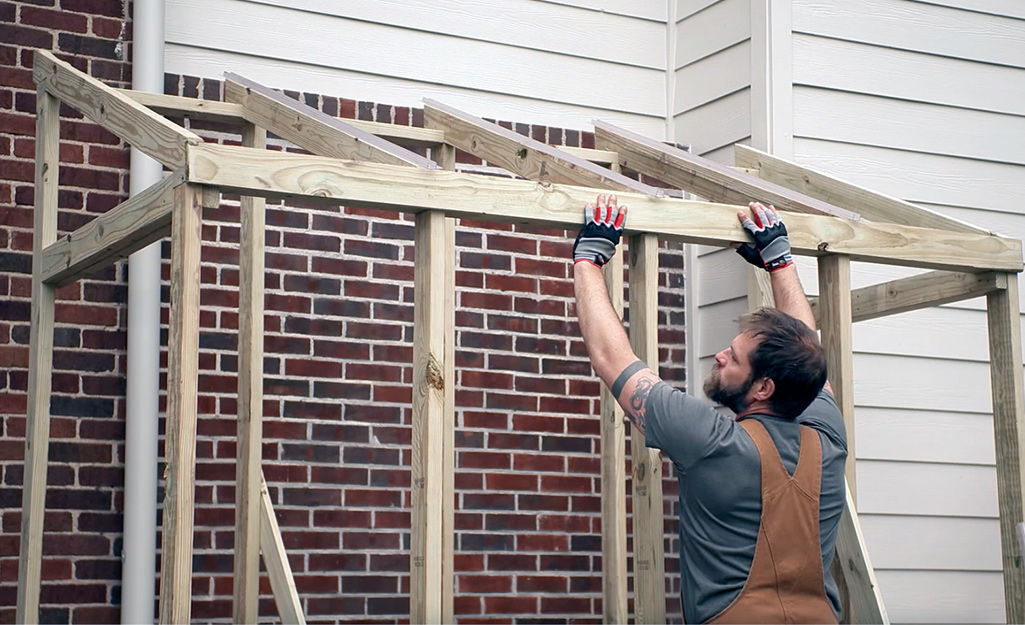 an image of a man building a lean to greenhouse