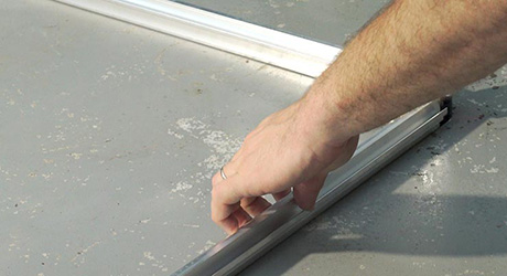 A person assembling the base and corner uprights of a greenhouse. A person assembling the base and corner uprights of a greenhouse.