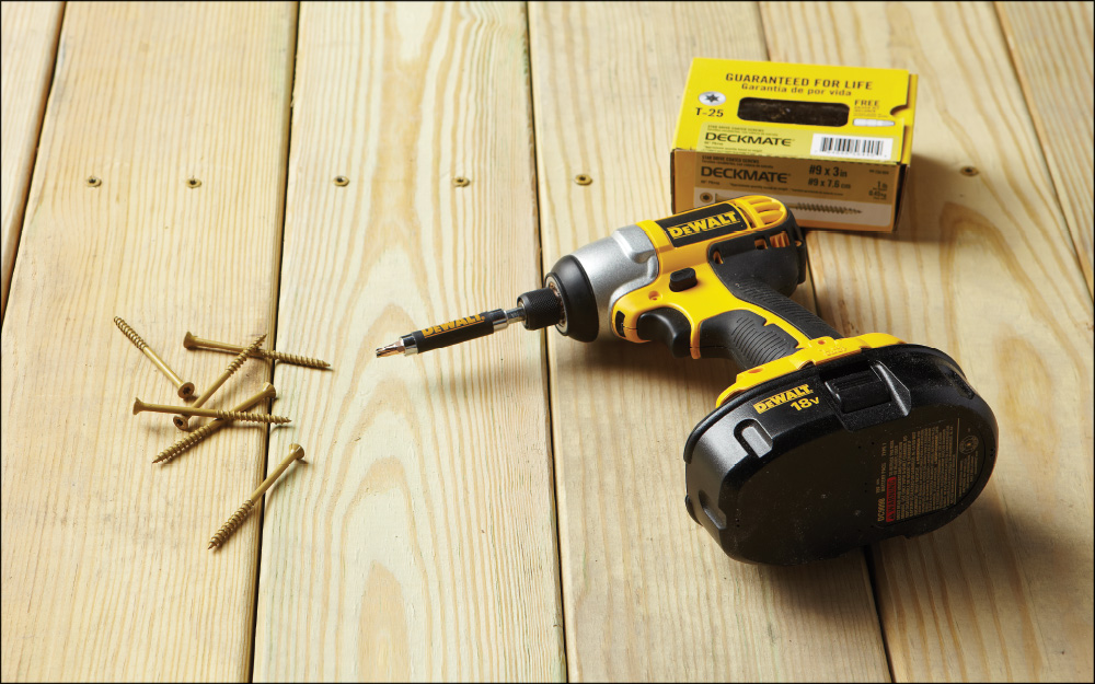 a power drill lying next to a bunch of screws a power drill lying next to a bunch of screws