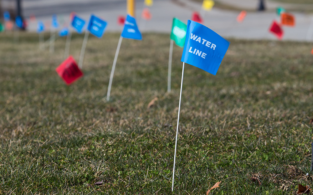 Red and blue utility flags in a lawn. Red and blue utility flags in a lawn.